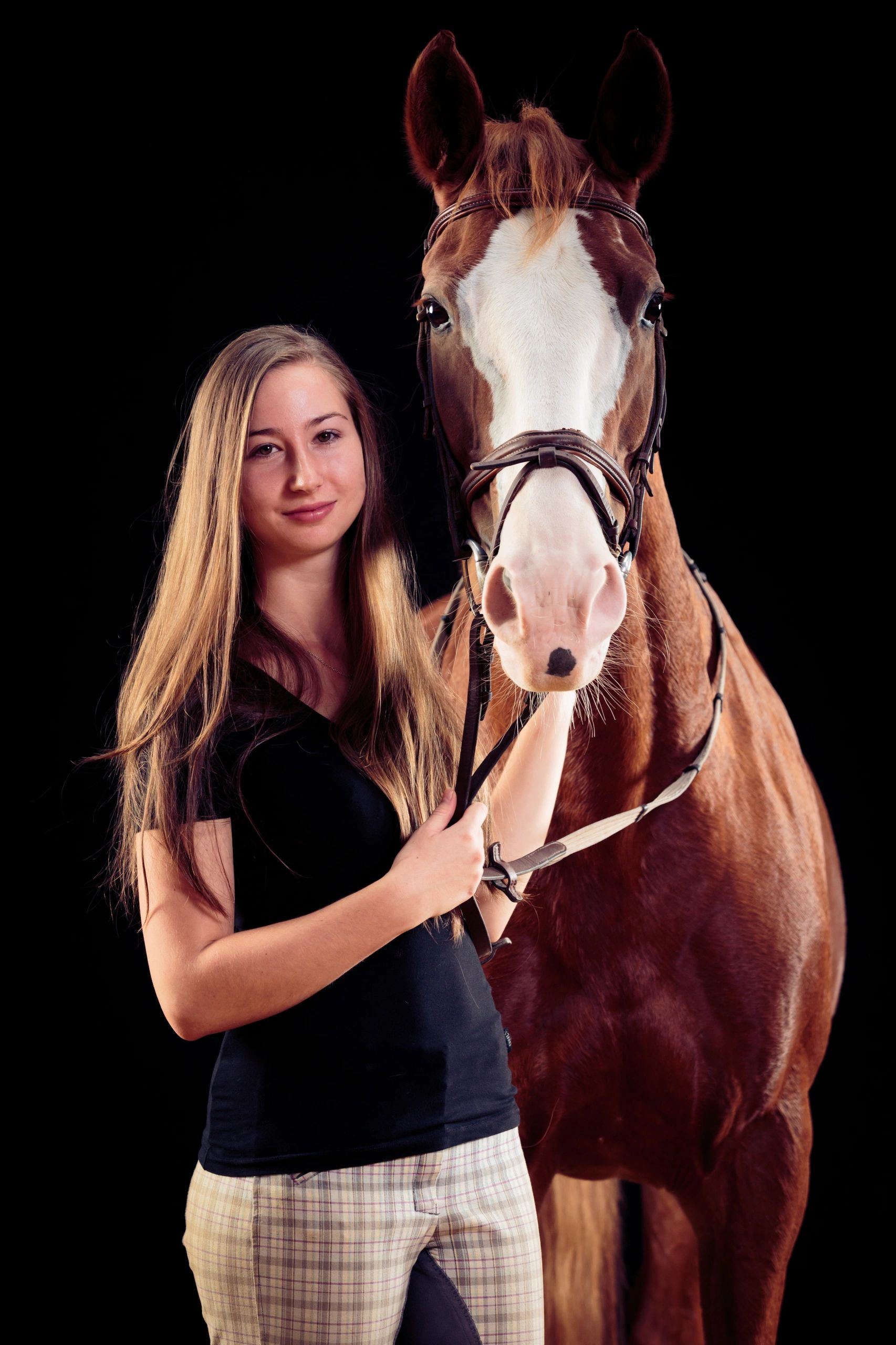 Woman with her horse on dark background