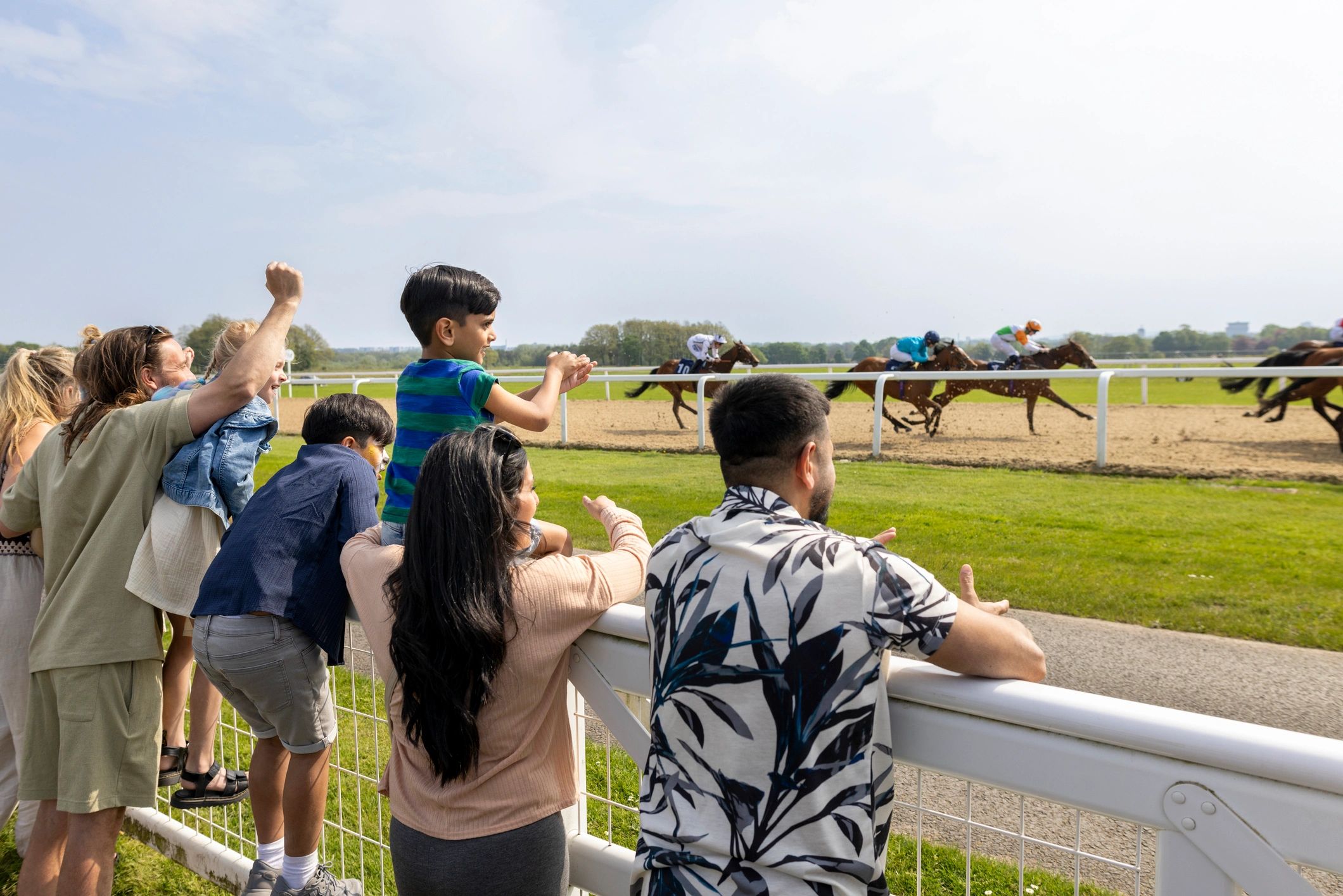Spectators cheering on horses at an event